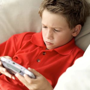 Young Boy (8-10) Sitting on a Couch Playing a Video Game